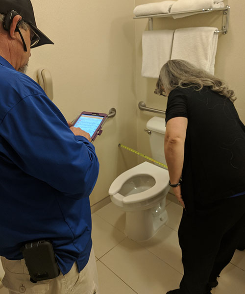 Two Life Quest team members measuring toilet center line distance from side wall