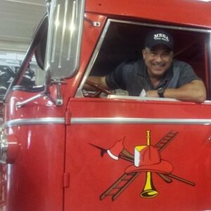 Tony Del Rio sitting in the driver's seat of a fire engine