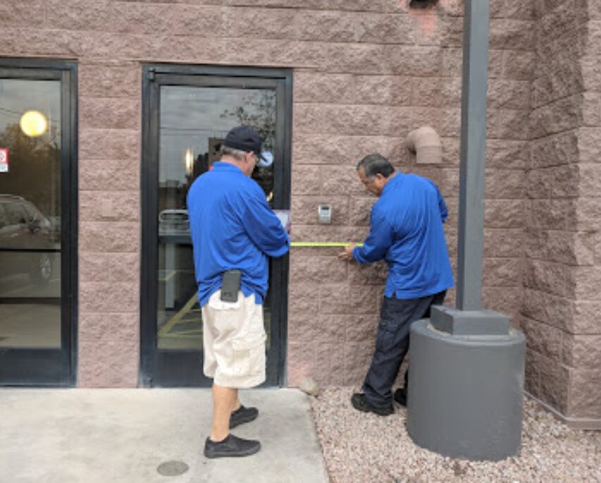 Two Life Quest team members conducting a survey of a door